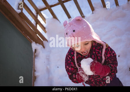 Cute girl licking la neige durant l'hiver Banque D'Images