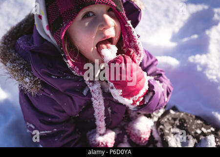 Portrait of cute girl licking snow Banque D'Images