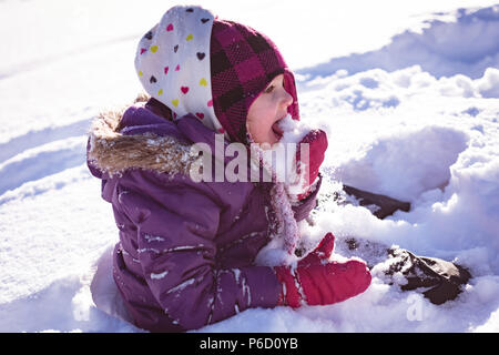 Cute girl licking snow Banque D'Images