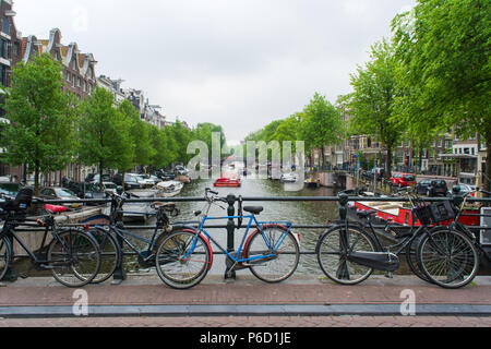 Amsterdam, Pays-Bas - mai 201 : Beau lever du soleil d'été sur le patrimoine mondial de l'UNESCO célèbres canaux d'Amsterdam, aux Pays-Bas, avec des fleurs et des vélos sur un pont. Banque D'Images