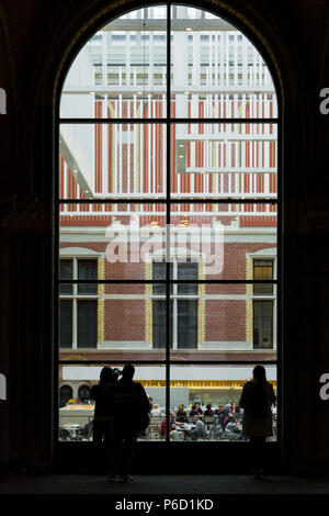 Amsterdam, Pays-Bas - Mai 2018 : les personnes à la recherche d'une grande fenêtre parmi les visiteurs dans un hall principal du nouvel atrium du Rijksmuseum. Entrée au musée, décorations de plafond massive et les gens en néerlandais musée national. Banque D'Images