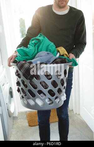 Man holding panier de vêtements blanchisserie Banque D'Images