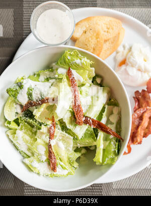 Servi avec salade césar au bacon croustillant et pocher egg Banque D'Images