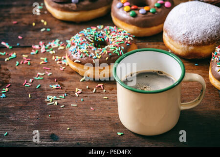 Le petit-déjeuner gratuit. Beignes et café, krepfen et saupoudre de sucre en poudre, de nombreux sur fond de table en bois. Banque D'Images