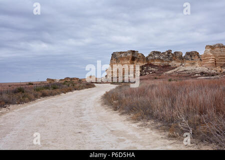 La route sinueuse à Castle Rock badlands, Kansas menant à la formations de roche calcaire érodé par l'intermédiaire de prairie Banque D'Images