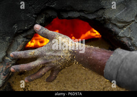 Un travailleur est en train de faire le travail de carburant dans l'enveloppe du riz à l'Upazila, Ishwardi Pabna Division District à Rajshahi, Bangladesh. Banque D'Images