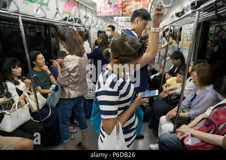 À l'est interdit de parler au téléphone dans des lieux publics pour éviter de déranger les autres, les Japonais se divertir à l'aide de leur configuration d'autres façons, Tokyo, Japon Banque D'Images