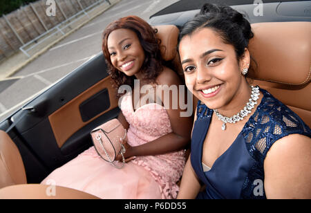 Les filles vêtues de leurs plus beaux atours arriver dans une limousine pour leur école Prom, Farnham, Surrey, Royaume-Uni. 22 juin 2018. Banque D'Images