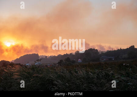 West Pennine Moors , Royaume-Uni, 29 juin 2018. Les incendies autour de Rivington Pike et Winter Hill à l'Ouest le ciel Pennine Moors remplir de fumée, à la dérive sur les villes ci-dessous tout en fin de soirée, Sun continue à briller fortement et la longue période de sécheresse se poursuit avec aucun signe de décomposition. Banque D'Images