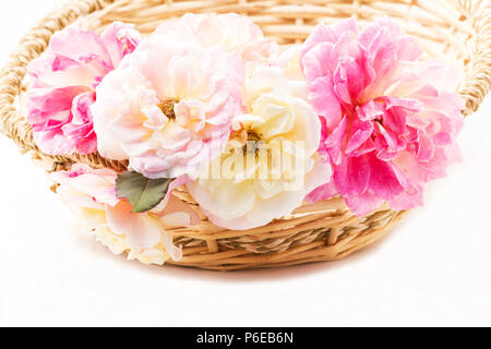 Roses dans un panier sur fond blanc Banque D'Images