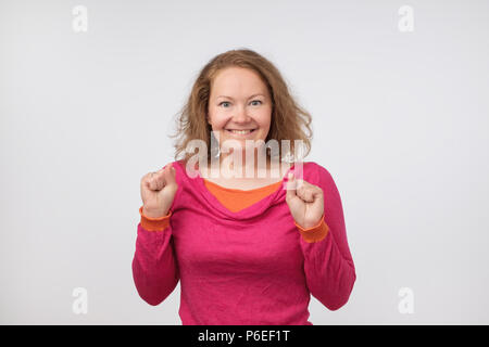 Surpris young woman smiling and holding ses poings près de visage. Elle est choquée par le prix de vente. c'est vrai. Banque D'Images