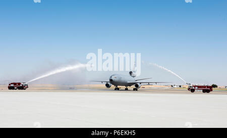 Les camions incendie arroser un KC-10 Extender après son achèvement d'un "fini" Vol Pour Le Colonel John Klein, 60e Escadre, la mobilité de l'air à Travis Air Force Base, en Californie, le 27 juin 2018. Fini le "vol" de Klein est marqué dernier vol comme pilote et commandant de la 60e AMW. (U.S. Air Force photo de Kim Lan) Banque D'Images