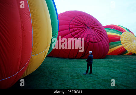 Image Retro du Walla Walla de montgolfières avec corde de dépôt de personne entourée de ballons colorés comme ils gonflent avant décollage sunrise Walla Banque D'Images
