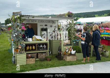 2 femmes debout, regardant l'affichage des sculptures et ornements de jardin sur stand à Chatsworth RHS Flower Show, Chatsworth House, Derbyshire, Angleterre, RU Banque D'Images