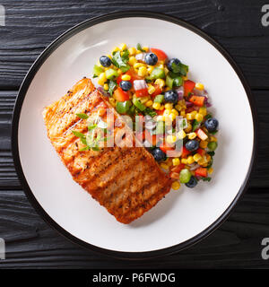 L'alimentation saine : Pavé de saumon grillé avec du poivre, du maïs, de bleuet et de salade d'oignon libre sur une plaque sur la table. haut Vue de dessus Banque D'Images