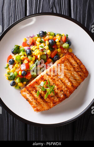 Saumon grillé steak au poivre, le maïs, de bleuet et de salade d'oignon sur gros plan sur la plaque de table. Haut Vertical Vue de dessus Banque D'Images