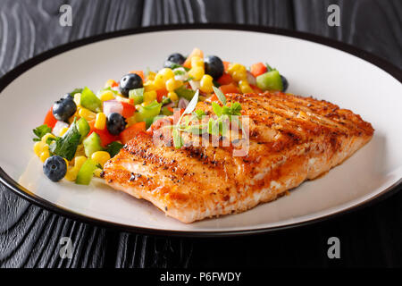 L'alimentation saine : Pavé de saumon grillé avec du poivre, du maïs, de bleuet et de salade d'oignon libre sur une plaque sur la table horizontale. Banque D'Images