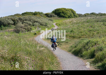 Un cycliste sur une section côtière de cycle SUSTRANS route 1 (également le chemin de la côte de l'Angleterre) à Druridge Bay, Northumberland Banque D'Images