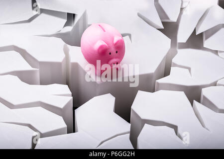 View Of Pink Piggybank sur surface blanche fissurée Banque D'Images