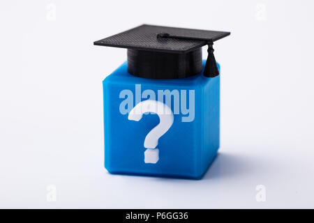 Graduation Hat noir sur m3 avec bloc Question Mark signe sur fond blanc Banque D'Images