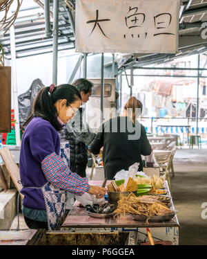 19 février 2018 - Tai O, Lantau Island, Hong Kong. Asian woman la préparation de produits de la mer séchés pour les vendre au marché local du village de pêcheurs de Tai O Banque D'Images