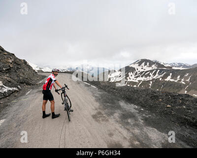 Le cycliste se trouve à côté de son vélo sur le dessus de col Le col de la bonette dans les alpes françaises Banque D'Images