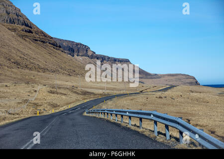 Avec aucun autre véhicule en vue, une route en emanders la distance entre les collines et la mer sur la péninsule de Snæfellsnes Icleand Banque D'Images