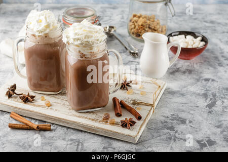 Chocolat chaud avec de la crème fouettée en pot Mason et les guimauves Banque D'Images