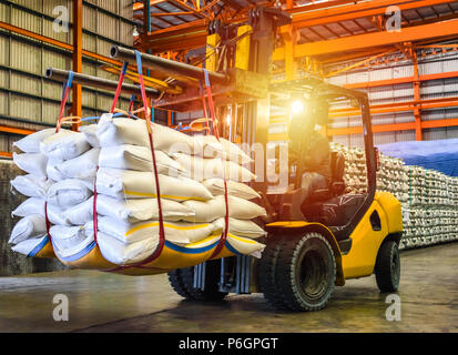Manutention Chariot élévateur d'entrepôt à l'intérieur des sacs de sucre blanc pour l'exportation. La distribution, la logistique Import Export, d'entrepôt commercial, concept. Banque D'Images