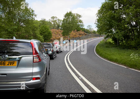 L'attente aux feux de voitures temporaires à des travaux sur une interdiction de dépasser section de l'A591 près de Keswick dans le lake district cumbria england uk Banque D'Images