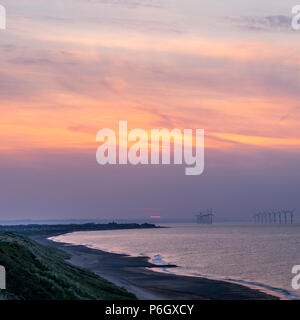 Éoliennes et de redcar marske falaises au coucher du soleil Banque D'Images