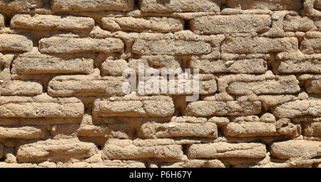 Mur en briques de boue à la main la création d'un modèle et la texture avec la lumière du soleil formant des ombres Banque D'Images