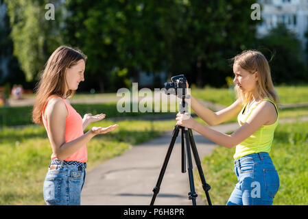 Deux filles lycéenne. L'été dans la nature. Enregistrer une vidéo sur l'appareil photo. Effectue une vidéo diffusée sur Internet. La notion de jeunes blogueurs et vlog Banque D'Images