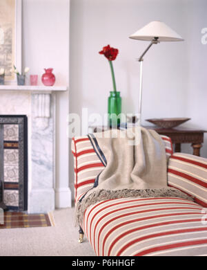 Jeter sur la laine crème beige rouge +canapé rayé dans maison moderne salon avec chrome lampe de plancher Banque D'Images
