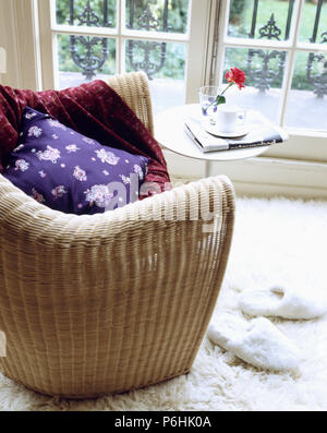 Close-up of modern wicker fauteuil avec cujshion pourpre et de velours rouge jeter Banque D'Images