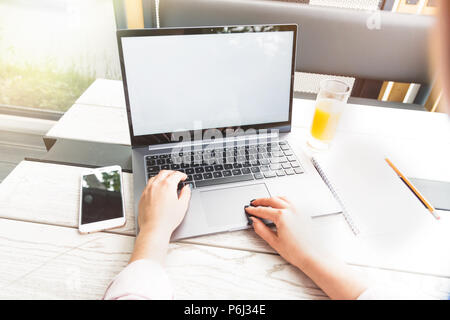 L'entreprise, de l'éducation, les gens et la technologie concept - close up de femmes travaillant sur ordinateur portable, smarthphone et jus d'orange sur la table Banque D'Images