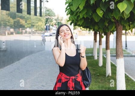 Attractive brunette businesswoman talking on mobile phone avec le client dans la rue Banque D'Images