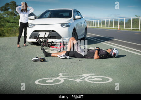 Cycliste homme inconscient allongé sur route après accident de la route, Selective focus Banque D'Images