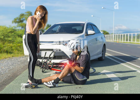 Cycliste homme inconscient allongé sur route après accident de la route Banque D'Images