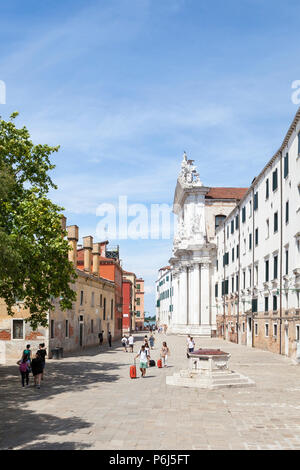 Refugee Église, Campo dei Gesuiti, Cannaregio, Venise, Vénétie, Italie avec les touristes à marcher avec assurance en passant l'ancien pozzo (tête de puits) Banque D'Images