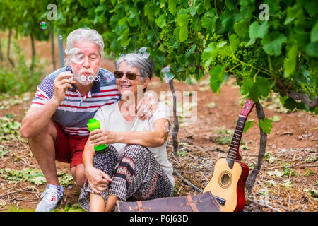 Drôle et belle maturité de jouer avec des bulles de savon. s'amuser comme des enfants à l'âge de 70 ans. sourire et rire avec amour et tendern Banque D'Images