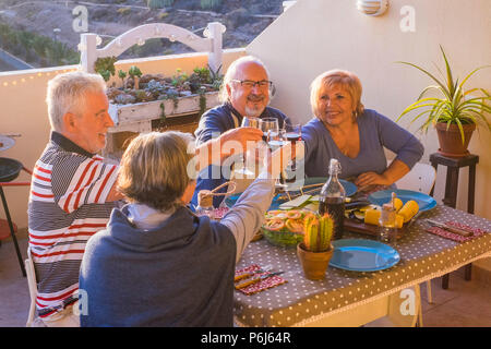 Groupe des belles senior adulte s'amuser et profiter d'un dîner sur la terrasse pour le outsood avec sourires et plaisir. L'activité à la retraite loisirs à va Banque D'Images
