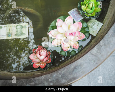 Fausses fleurs en plastique et de l'argent chinois flottant dans un grand désir de bronze électrique pour la prospérité Banque D'Images