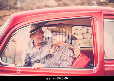 Beau Beau couple de senior people dans une vieille voiture vintage rouge profiter et rester ensemble dans les activité de loisirs de plein air. Marié et pour Banque D'Images