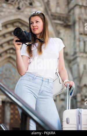 Woman 25 à 35 ans est prise de photos avec son appareil photo tout en voyage à travers la ville. Banque D'Images