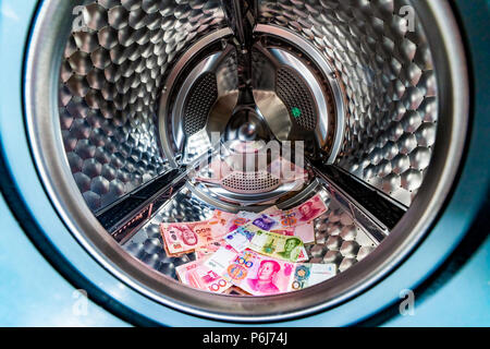 Le blanchiment Symbole, yuan chinois billets dans un lave-linge avec la porte ouverte Banque D'Images