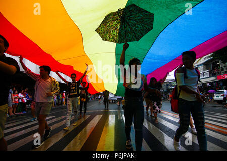 Les participants mars fierté tenir un drapeau arc-en-ciel pendant la parade. Des milliers de gay membres ont défilé dans les rues de Marikina, Manille comme ils ont participé cette année à la marche de la fierté. Banque D'Images
