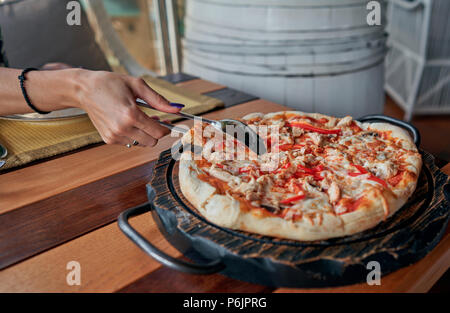 Fille prend une tranche de pizza à partir de la table Banque D'Images