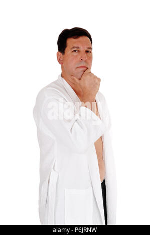 Un homme d'âge moyen standing dans un peignoir blanc avec une main sur son menton, à la recherche dans l'appareil photo, isolée pour fond blanc Banque D'Images