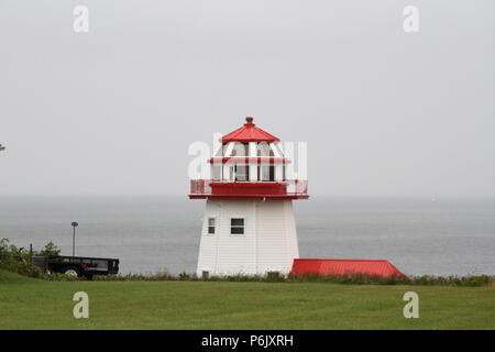 Phare rouge et blanc sur un jour brumeux Banque D'Images